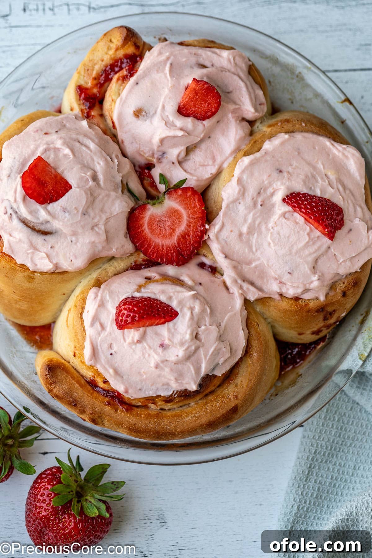 Luscious Strawberry Cinnamon Rolls 2 Frosted strawberry cinnamon rolls arranged beautifully on a serving dish.