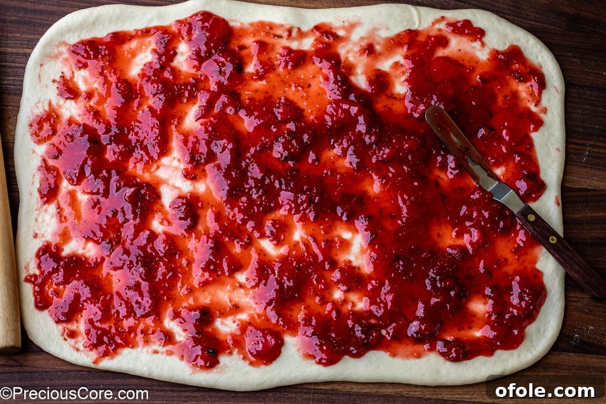 Luscious Strawberry Cinnamon Rolls 13 Strawberry compote spread evenly on rolled-out dough.