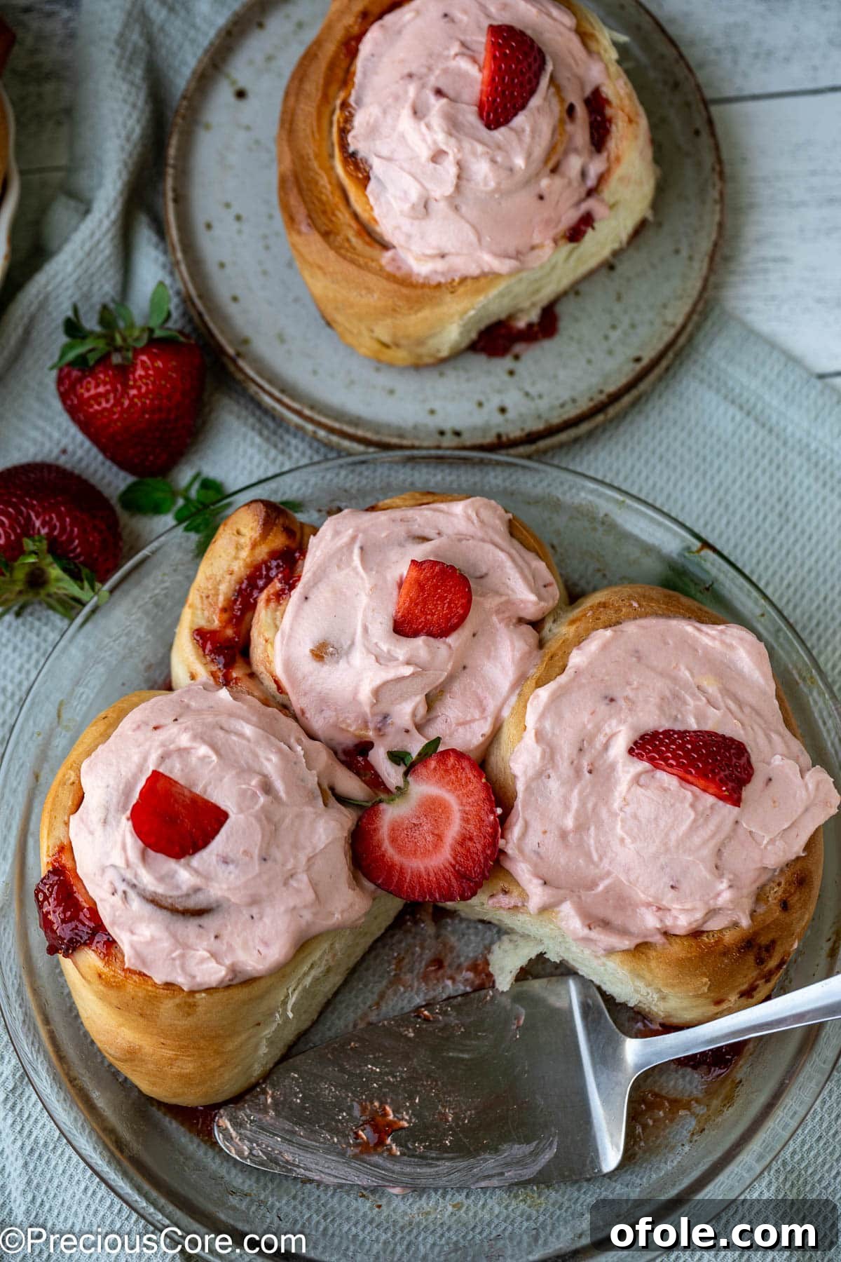 Luscious Strawberry Cinnamon Rolls 4 Plated strawberry cinnamon rolls with generous frosting and a hint of fresh strawberries.