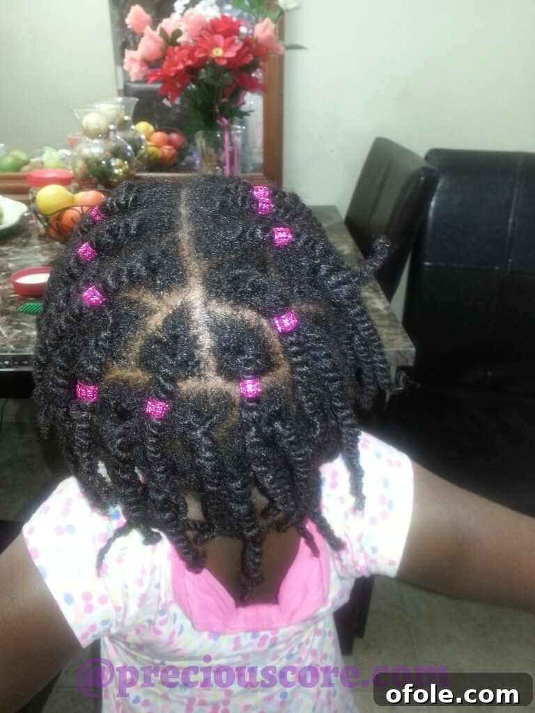Girl number one's finished natural hair twists with antique tube accessories, back view