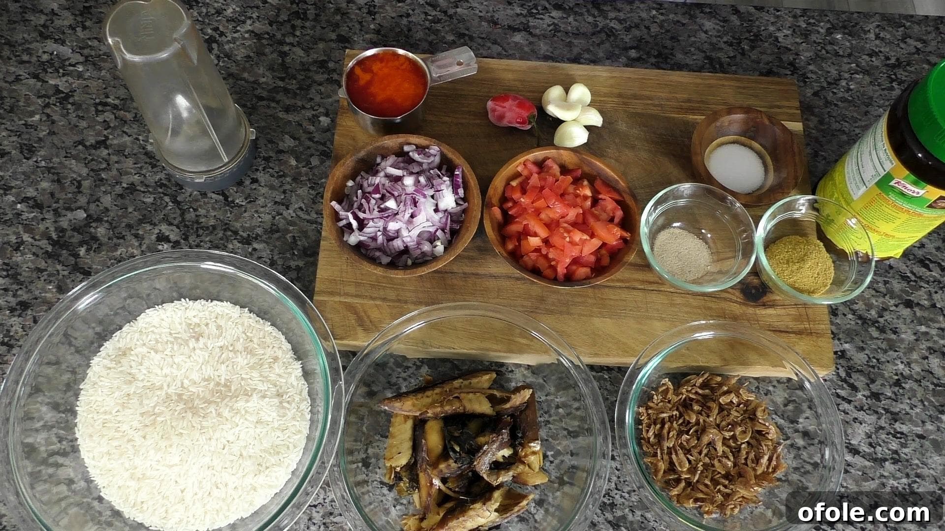 Various fresh ingredients for Njanga rice, including palm oil, tomatoes, onions, garlic, and crayfish.