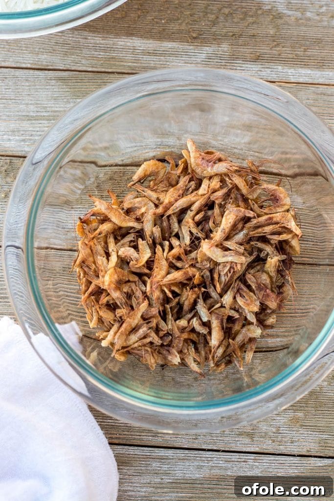 Dried crayfish in a small wooden bowl, ready for cooking.