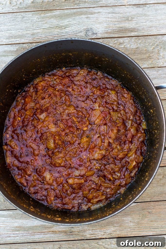 Sautéed tomatoes and palm oil sauce with garlic and crayfish, forming the base for palm oil jollof rice.