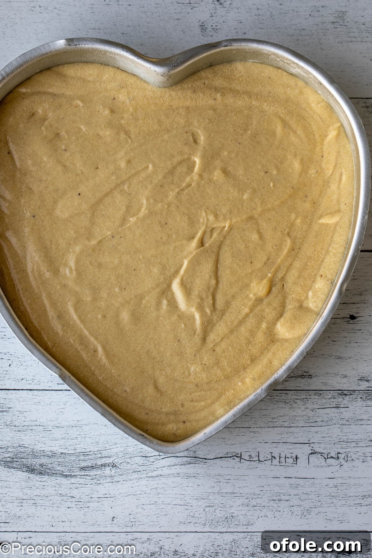Effortless Everyday Cake 9 Light, fluffy cake batter neatly poured into a greased heart-shaped baking pan, ready to be baked.