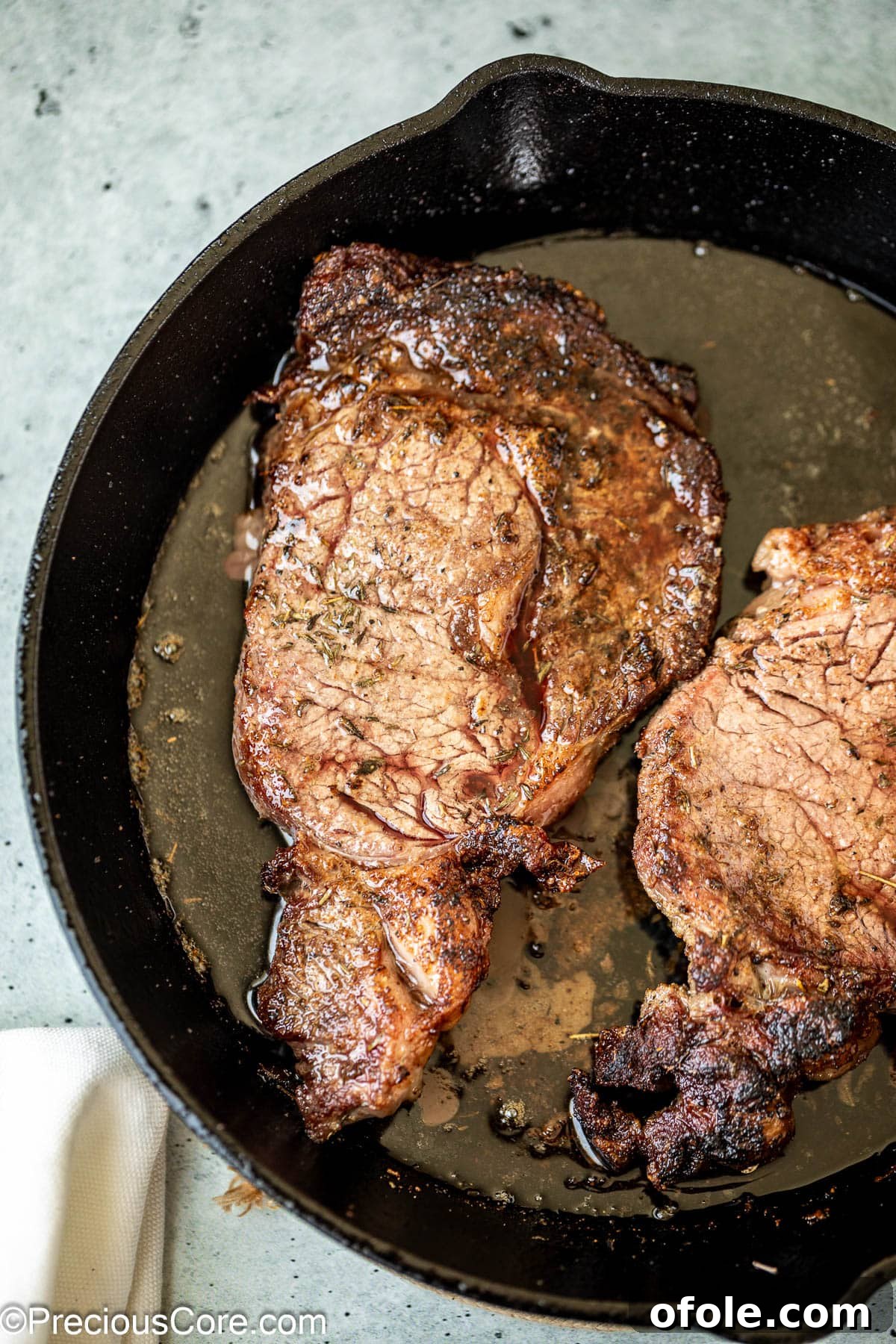Elevated Ribeye Steak Sandwich 6 Cooking ribeye steaks in a skillet.