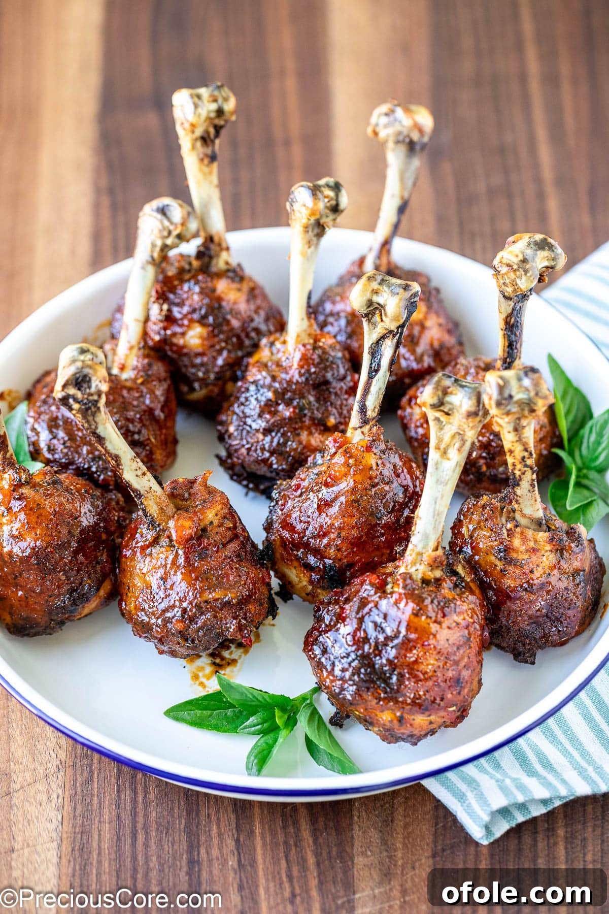 Plate of baked and glazed chicken lollipops.