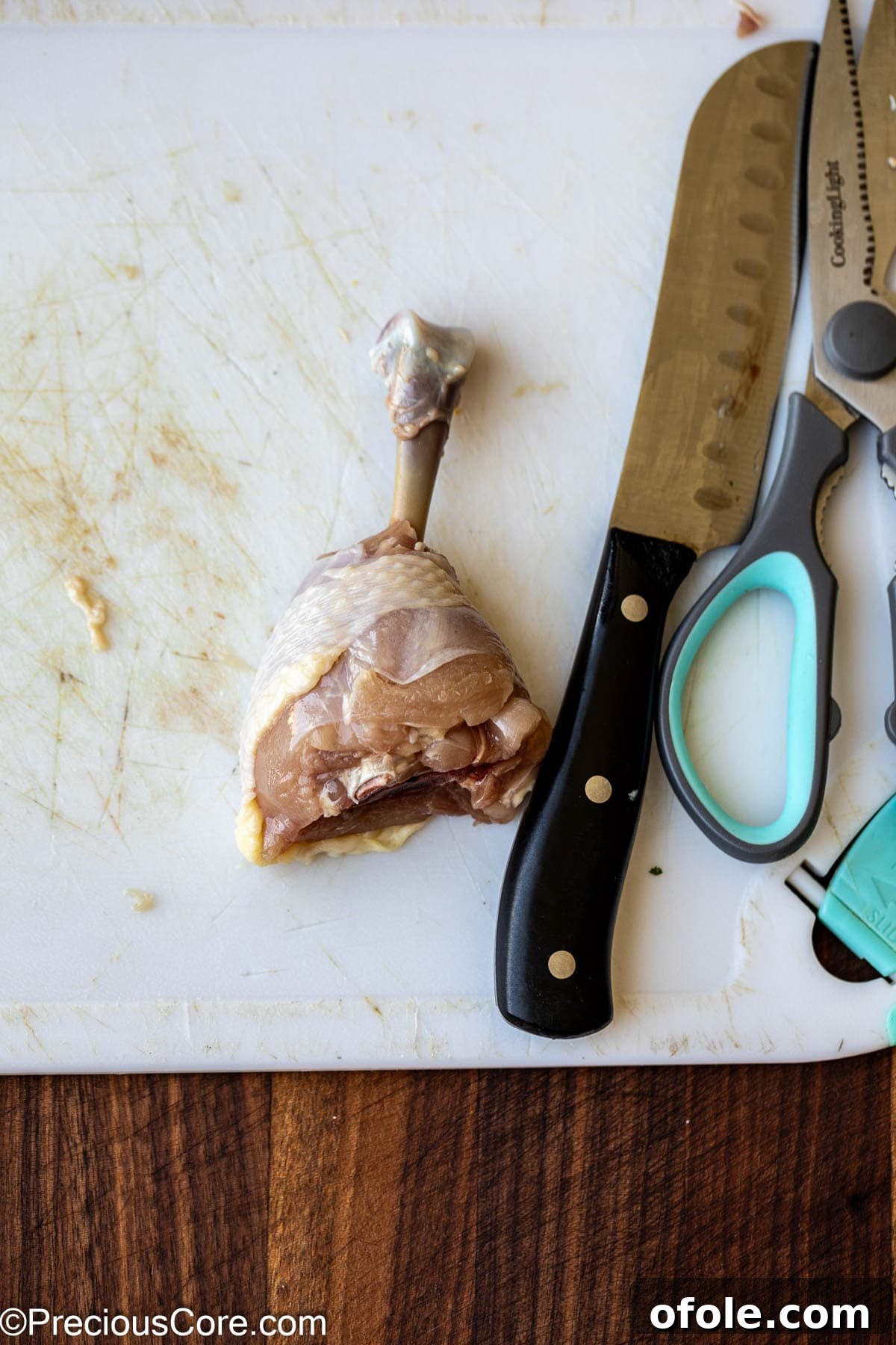 Knife, kitchen shears, and a chicken drumstick.