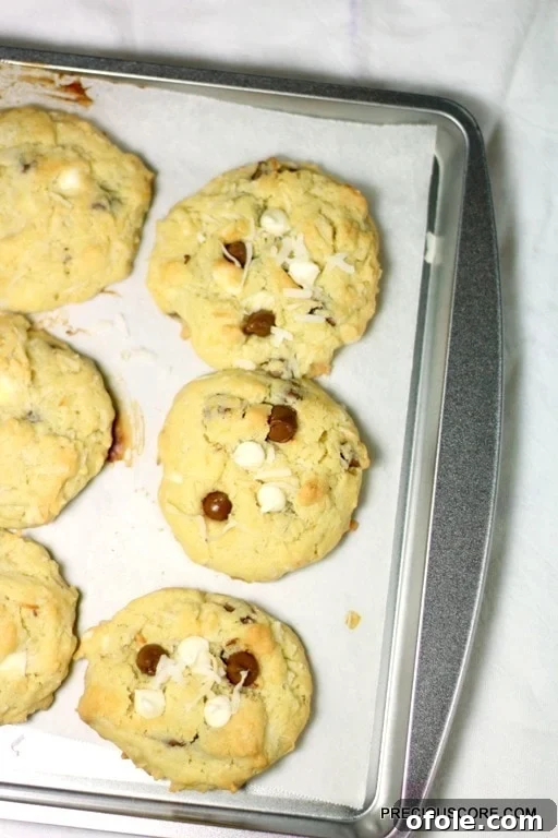 Tropical Coconut Chocolate Chip Cookies 7 Coconut chocolate chip cookies on a lined baking sheet.