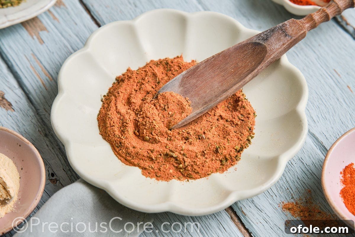 Cajun Flavor Hacks 10 Landscape image of a rustic wooden bowl filled with rich homemade Cajun seasoning.