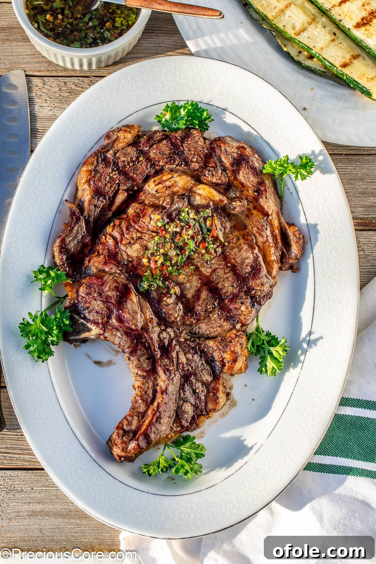 Prime Bone-In Ribeye 8 Bone in ribeye served on a white tray.