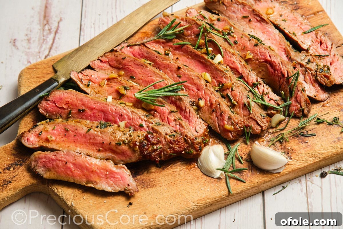 Wide shot of perfectly seared flank steak on a cutting board, ready to be served with accompaniments.