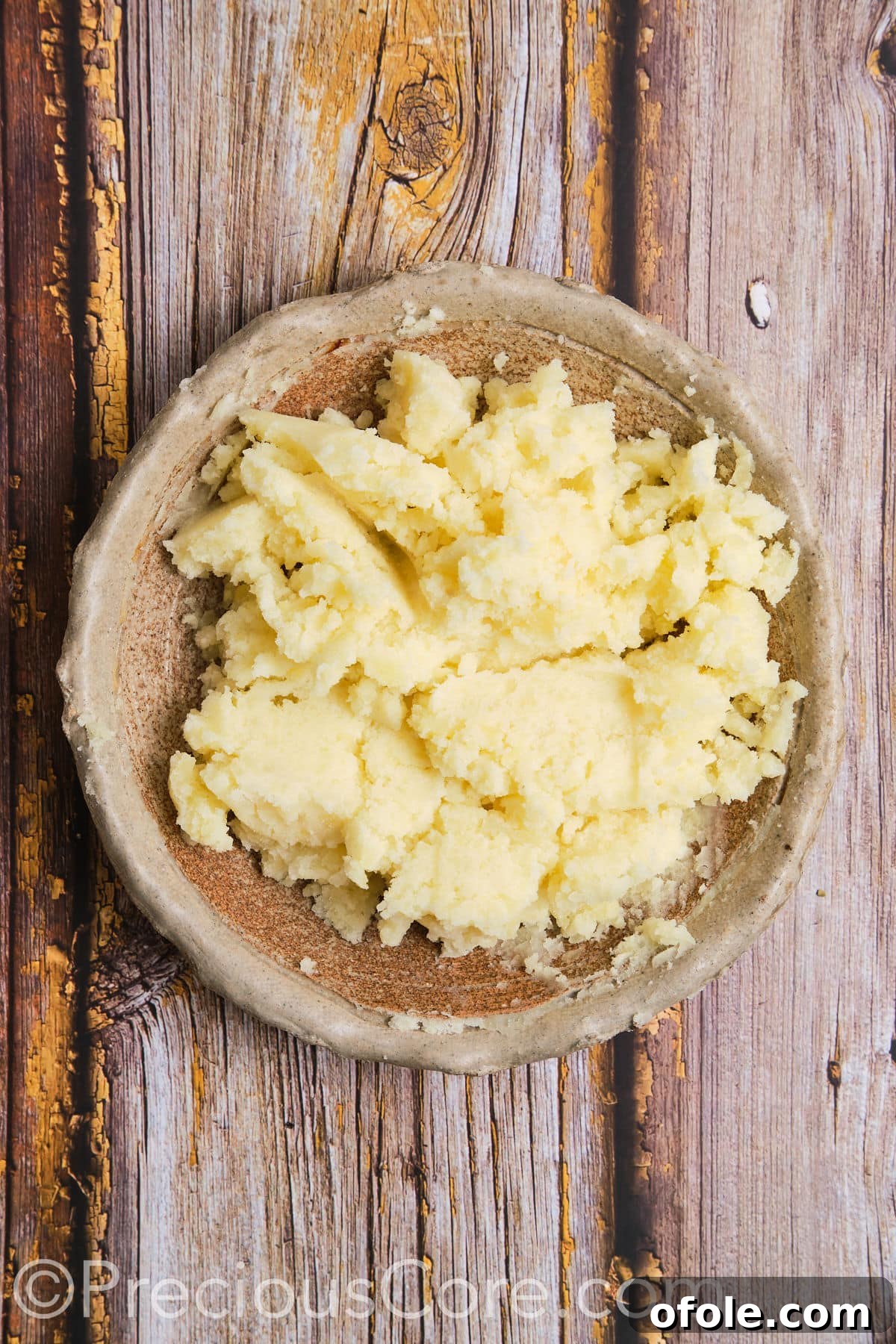 A bowl of perfectly mashed potatoes, smooth and ready for seasoning.