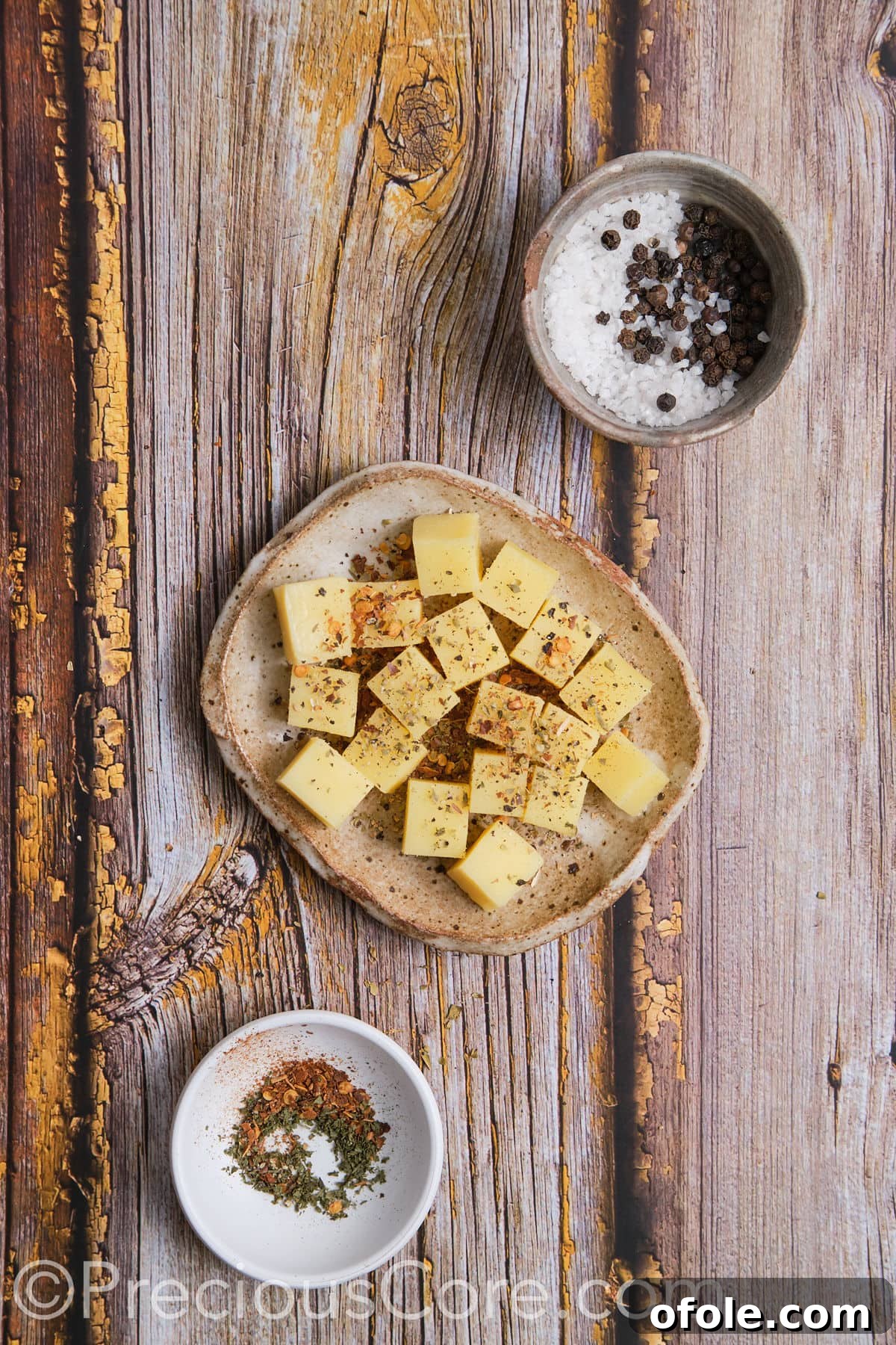 Seasoned cheese cubes neatly arranged on a plate, awaiting their turn in the potato balls.