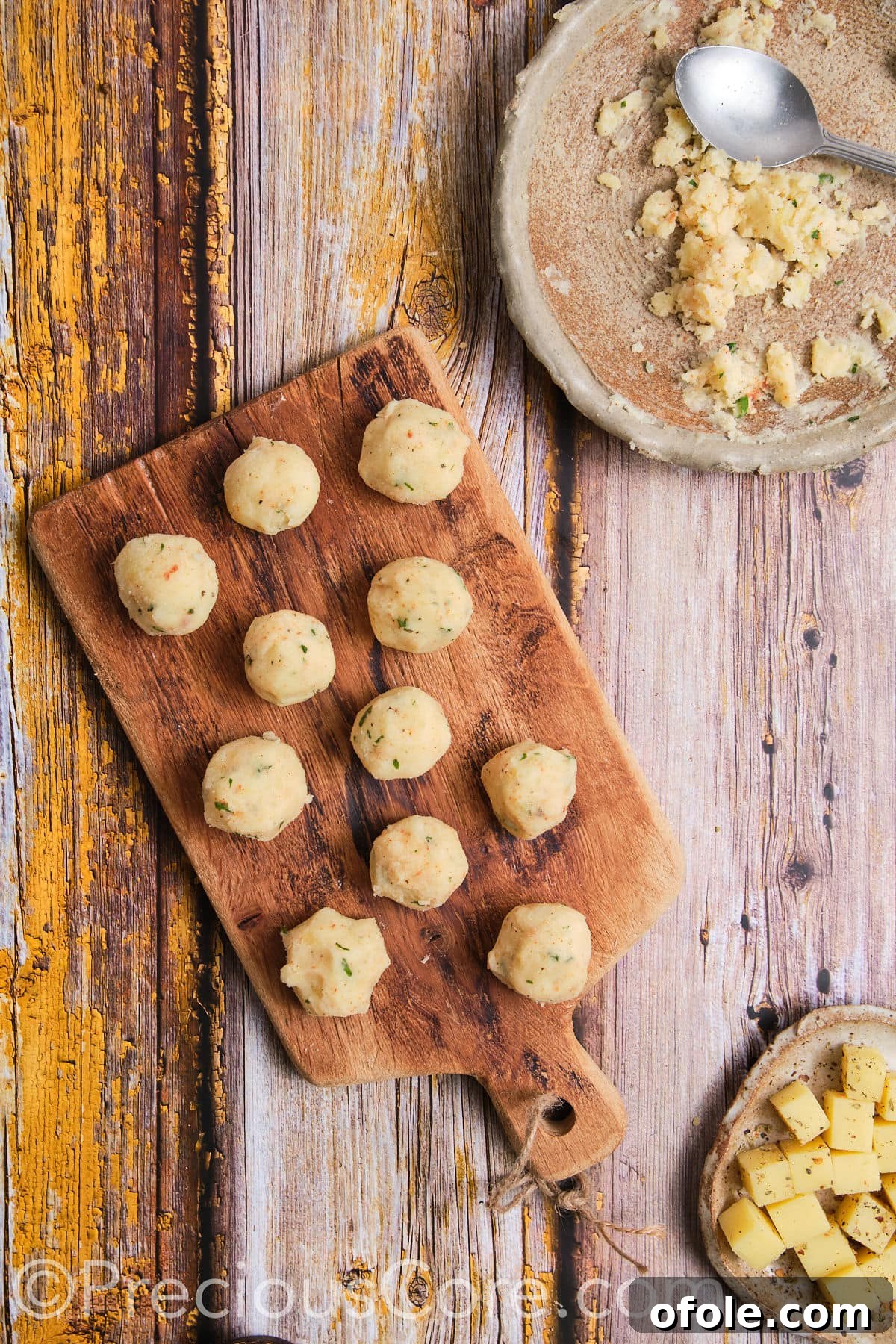 Small, uniform potato balls formed from mashed potatoes, ready for filling.