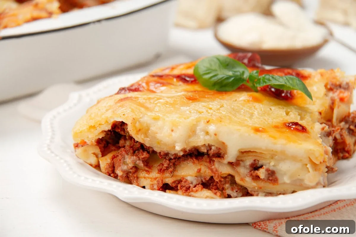 Creamy Béchamel Lasagna 15 A close-up, mouthwatering slice of homemade lasagna with béchamel sauce, revealing perfectly cooked layers of pasta, rich meat sauce, and creamy béchamel, topped with golden-brown cheese.