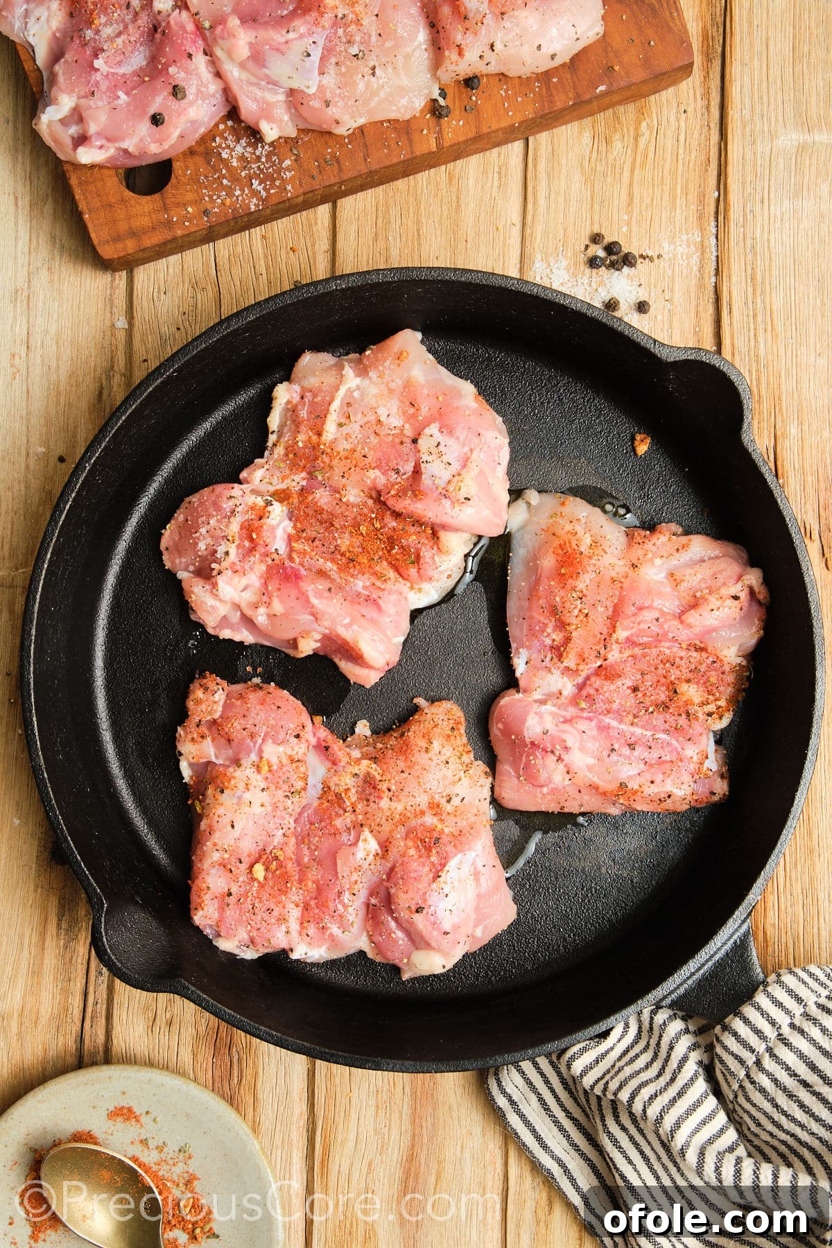 Juicy Skillet Chicken Thighs 12 Chicken thighs actively cooking and searing in a hot cast iron skillet, creating a perfect crust.