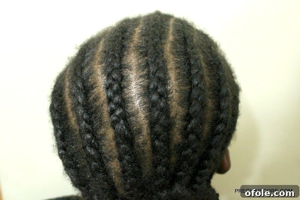 Close-up view of cornrow braiding in progress, showing a neat and tight base