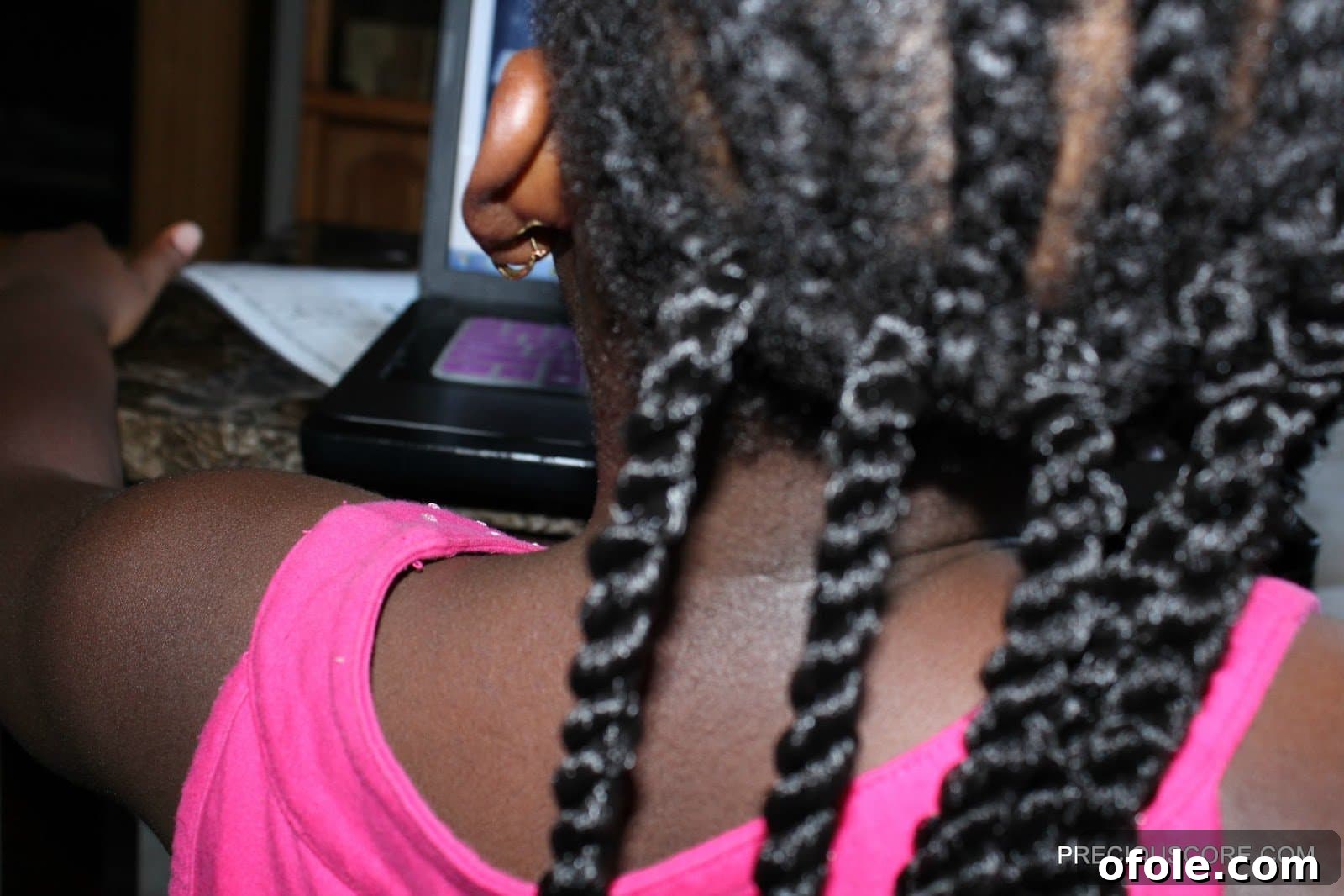 How to install crochet braids for beginners: Step 2, demonstrating inserting the crochet hook through a cornrow