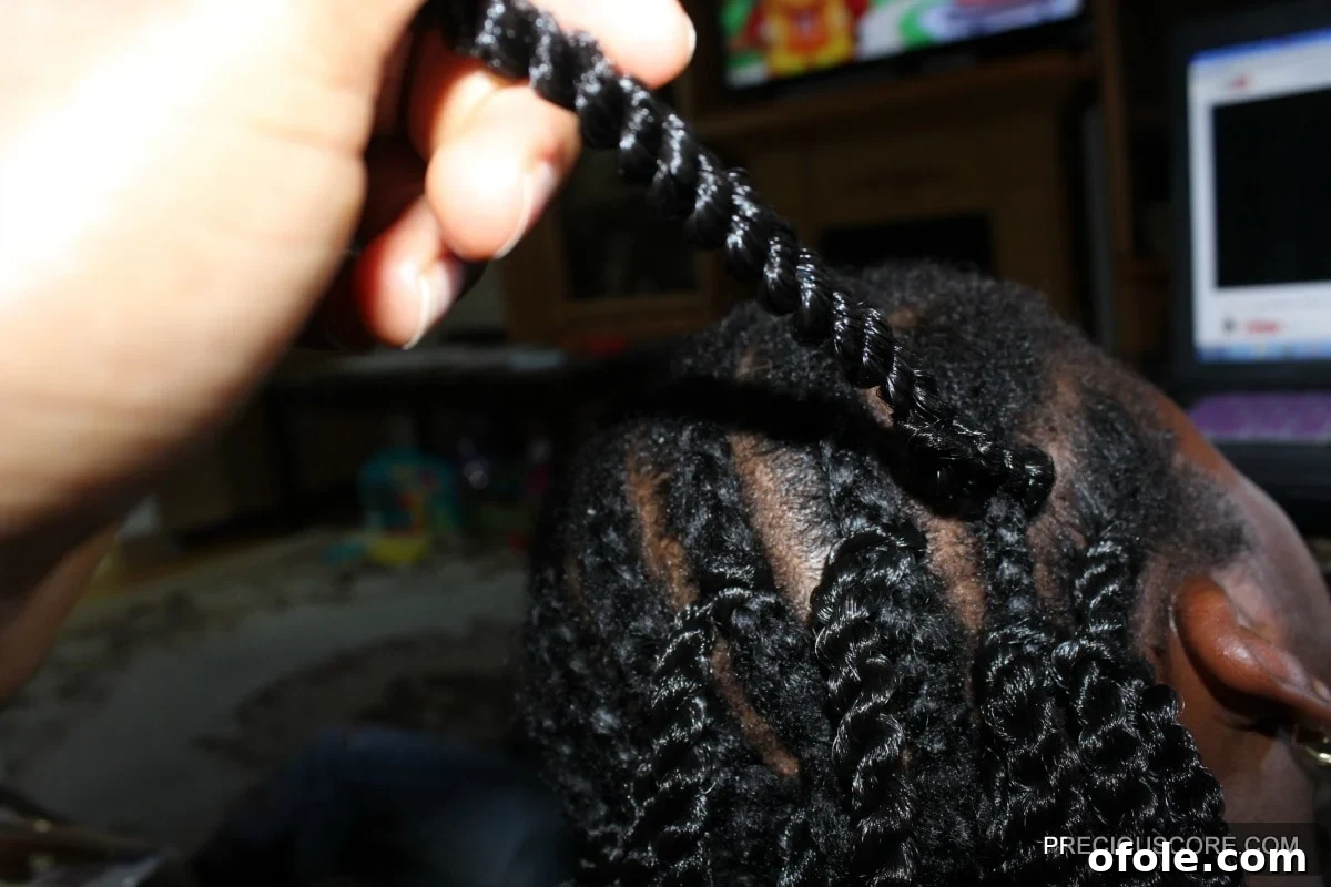Progress shot of continuously installing crochet braids across the head, showing even spacing
