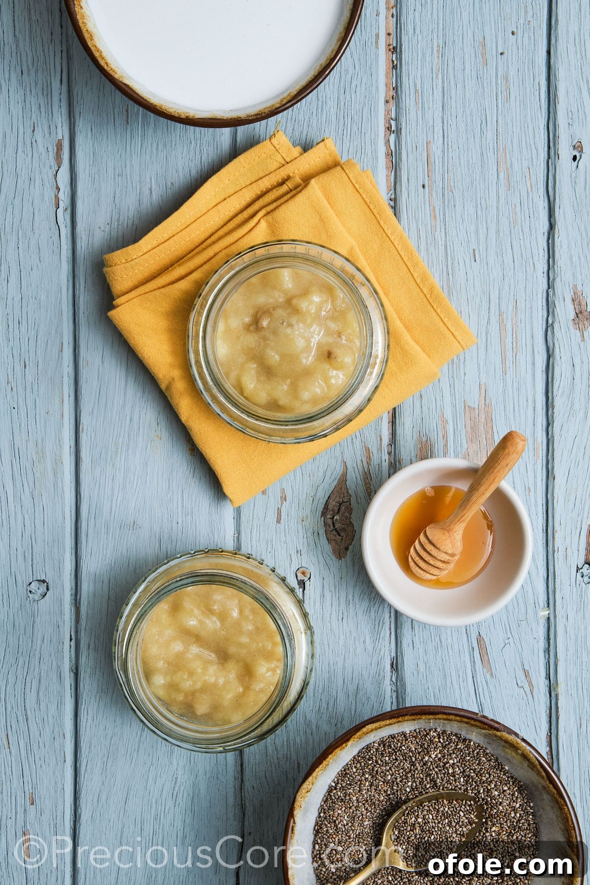 Adding the mashed bananas into individual glass jars.