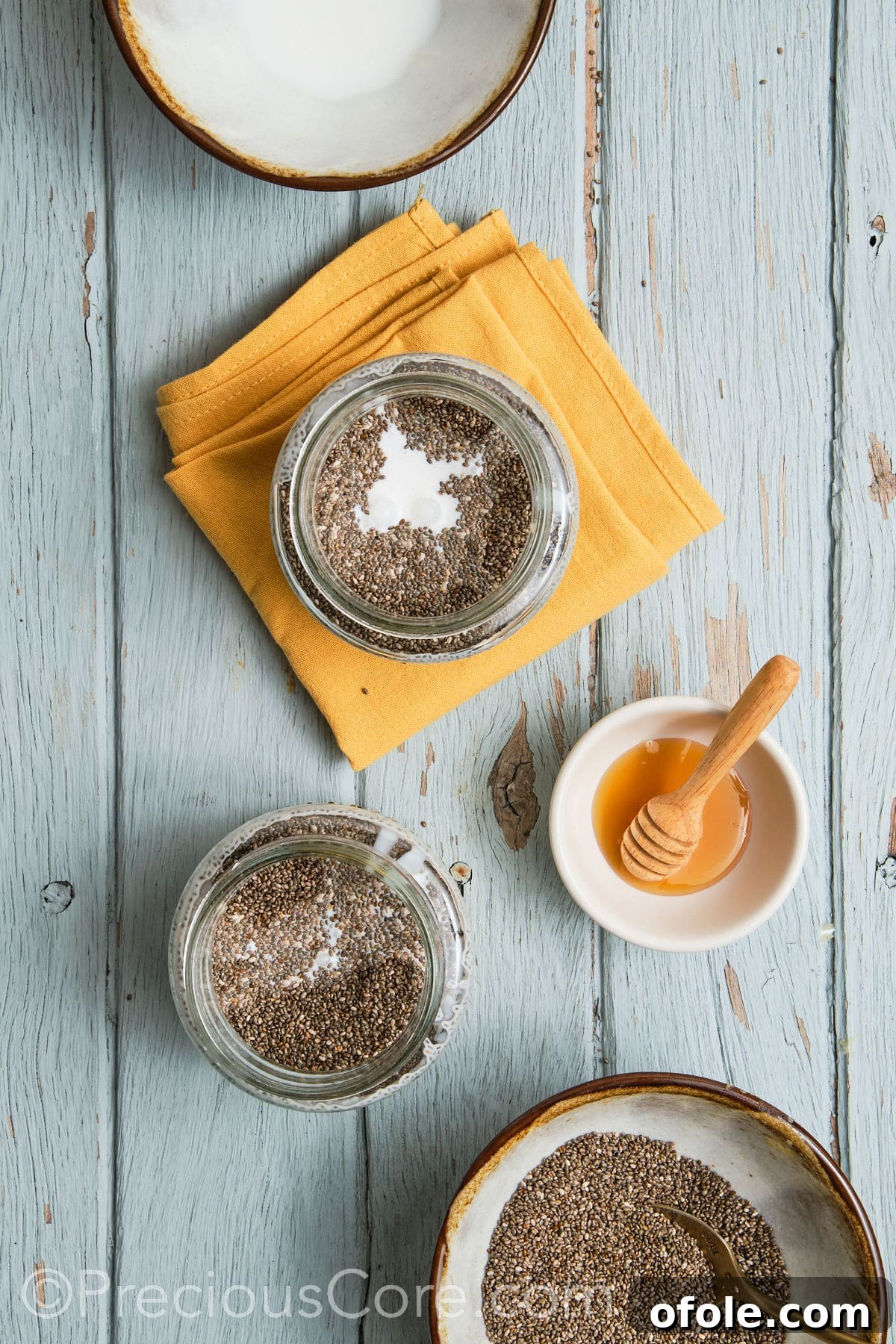 Pouring coconut milk into a glass jar with mashed bananas and other ingredients.