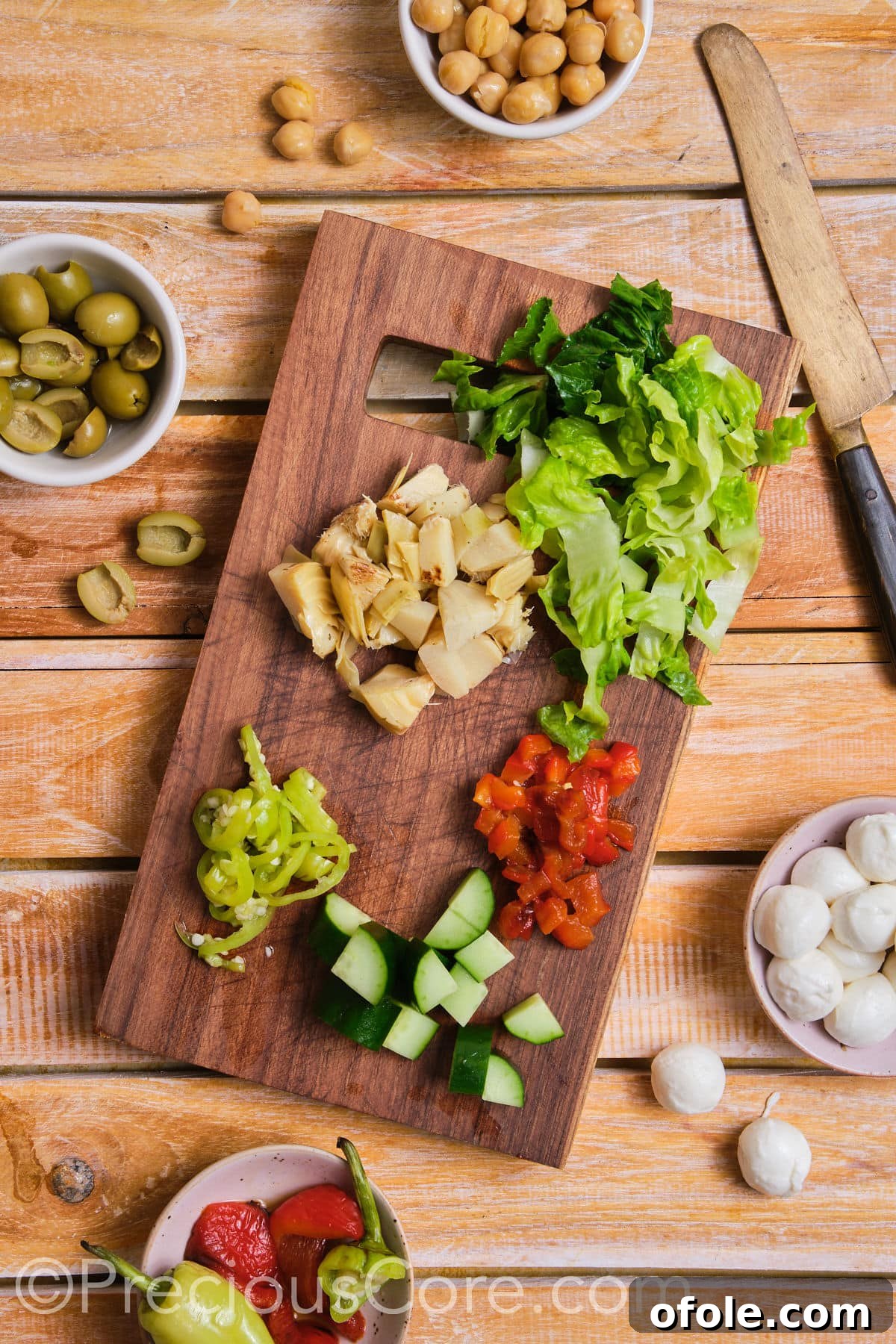 Ultimate Italian Chopped Salad 8 Precisely diced vegetables like tomatoes, onions, and cucumbers neatly arranged on a chopping board.