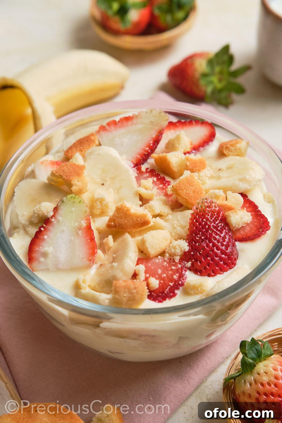 Dreamy Strawberry Banana Pudding 2 Delicious Strawberry Banana Pudding in a clear trifle dish, showcasing layers of creamy pudding, fresh strawberries, and ripe bananas.
