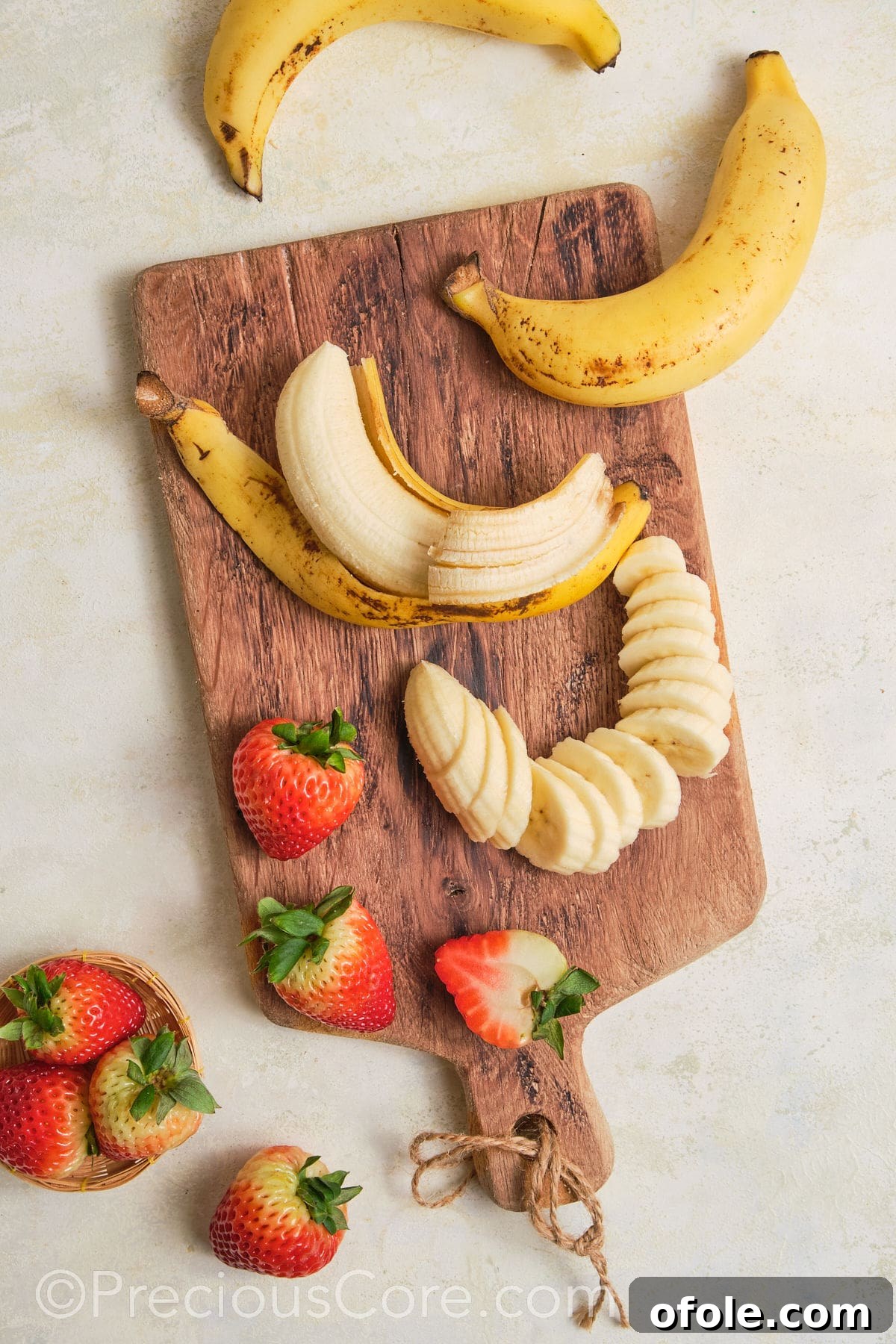 Dreamy Strawberry Banana Pudding 11 Fresh bananas and strawberries being carefully sliced on a cutting board, preparing them for layering in the pudding.