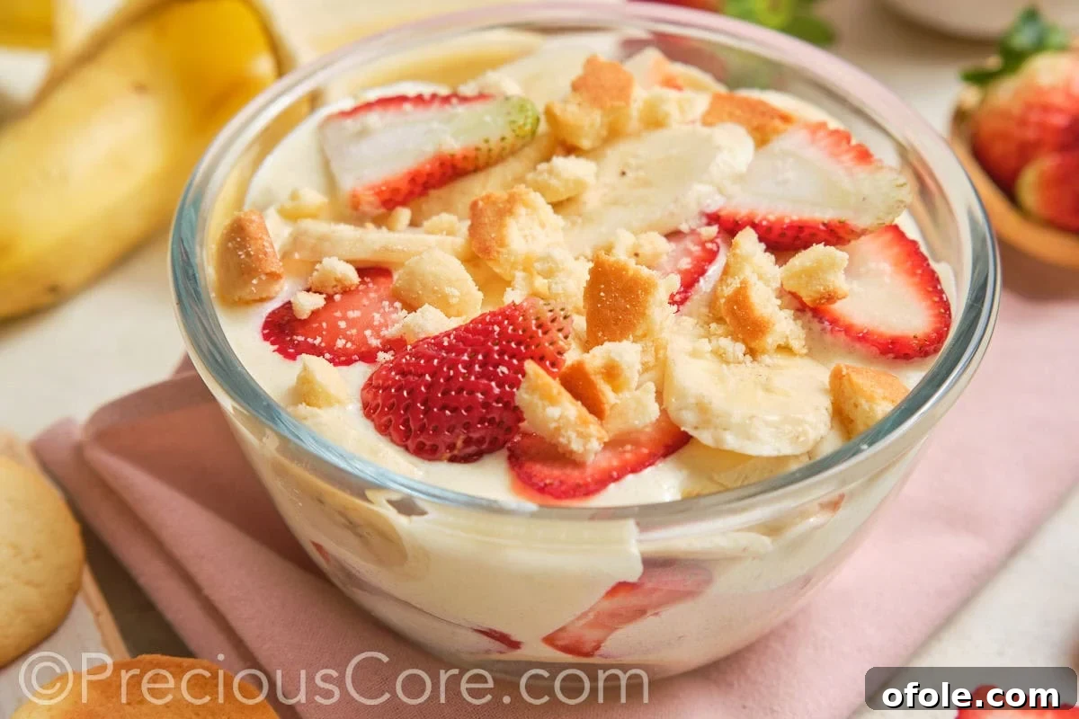 Dreamy Strawberry Banana Pudding 16 A beautifully layered glass bowl of homemade pudding dessert, clearly showing the different components, ready for serving or storing.