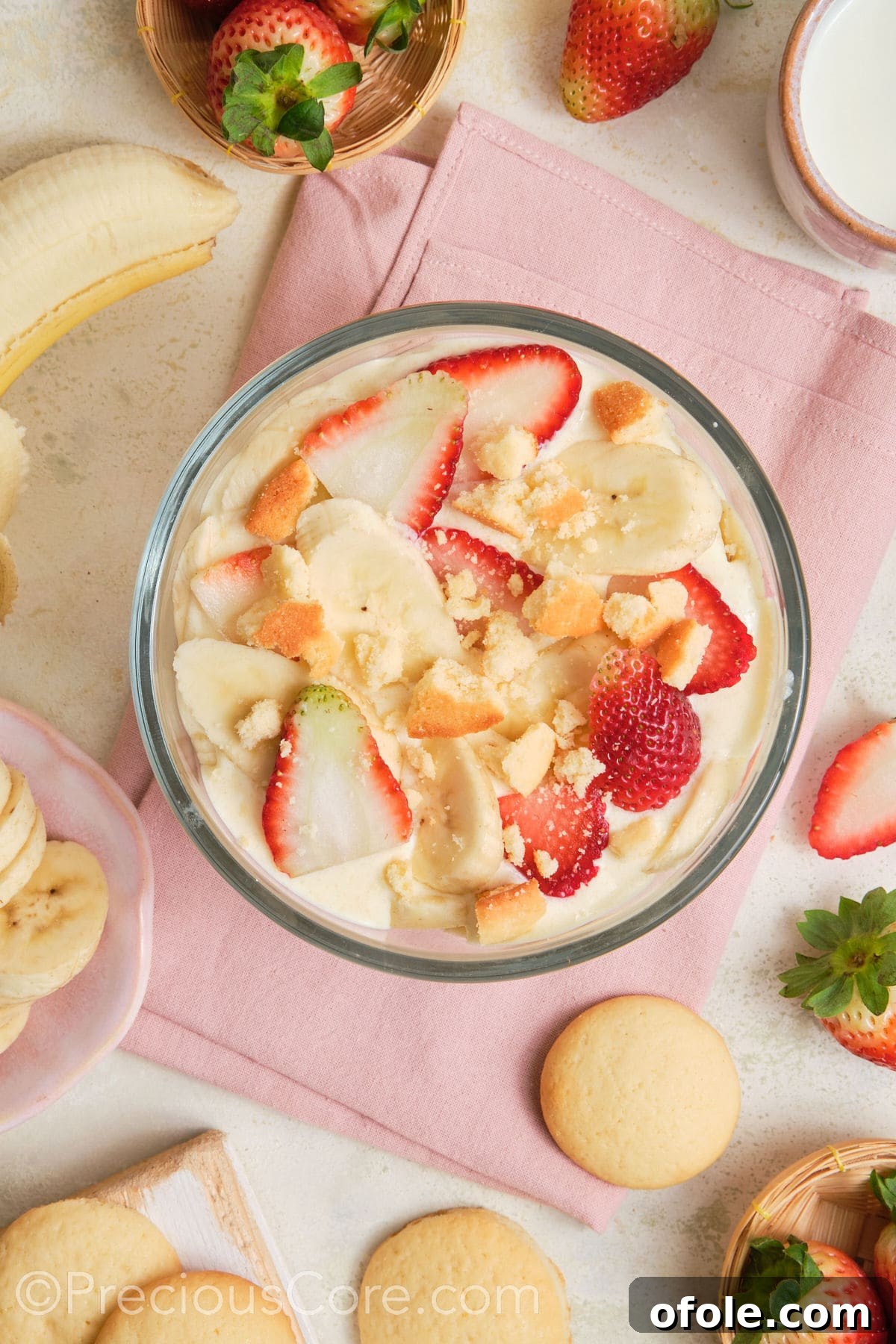 Dreamy Strawberry Banana Pudding 3 Close-up of freshly prepared banana pudding, generously topped with vibrant strawberry slices and classic vanilla wafer cookies.