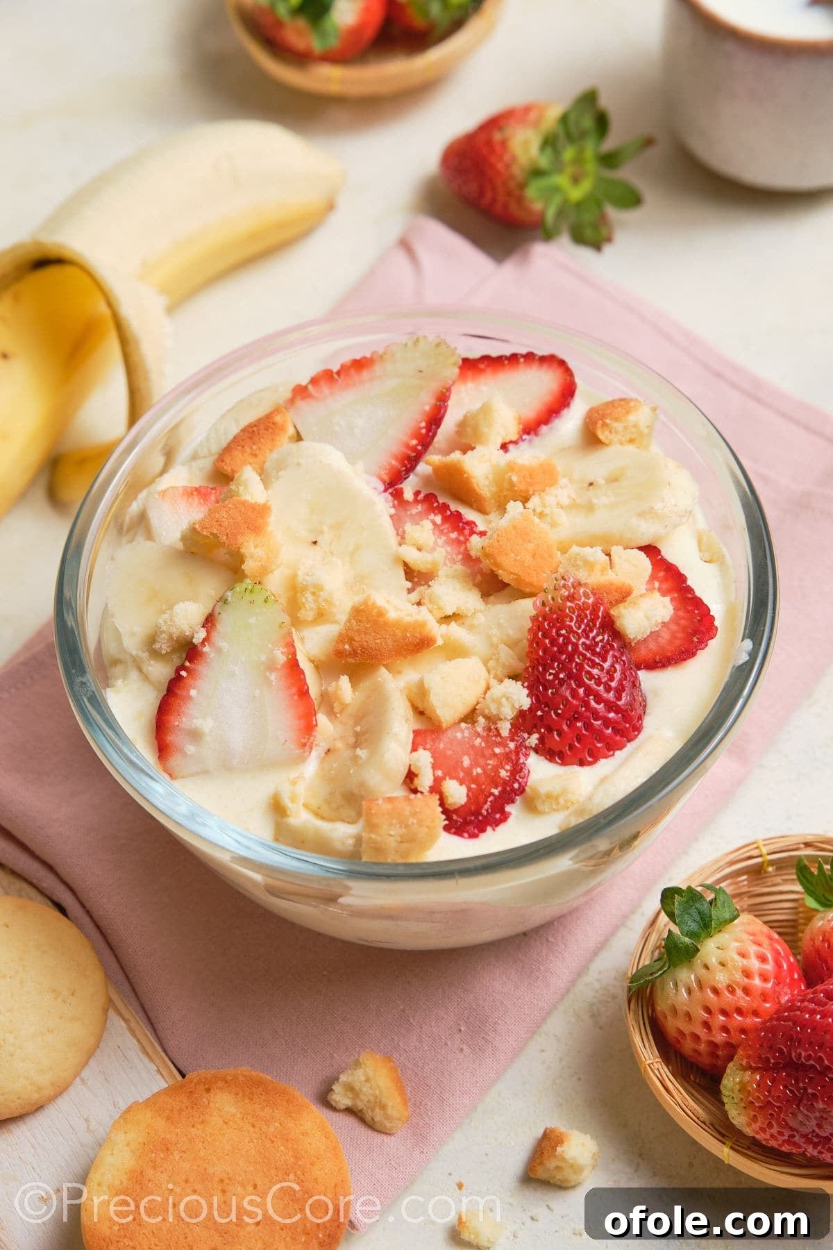 Dreamy Strawberry Banana Pudding 6 A close-up shot of creamy white pudding adorned with artfully arranged slices of fresh strawberries and bananas, ready to be enjoyed.