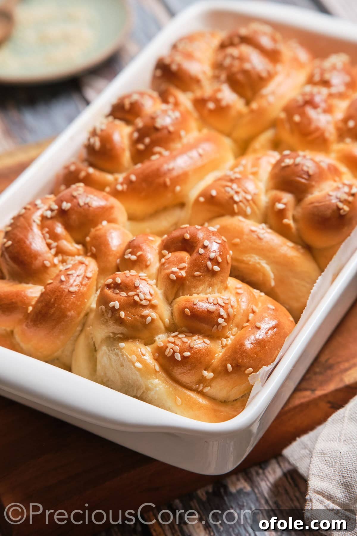 A baking dish filled with perfectly baked homemade challah rolls, ready to serve.
