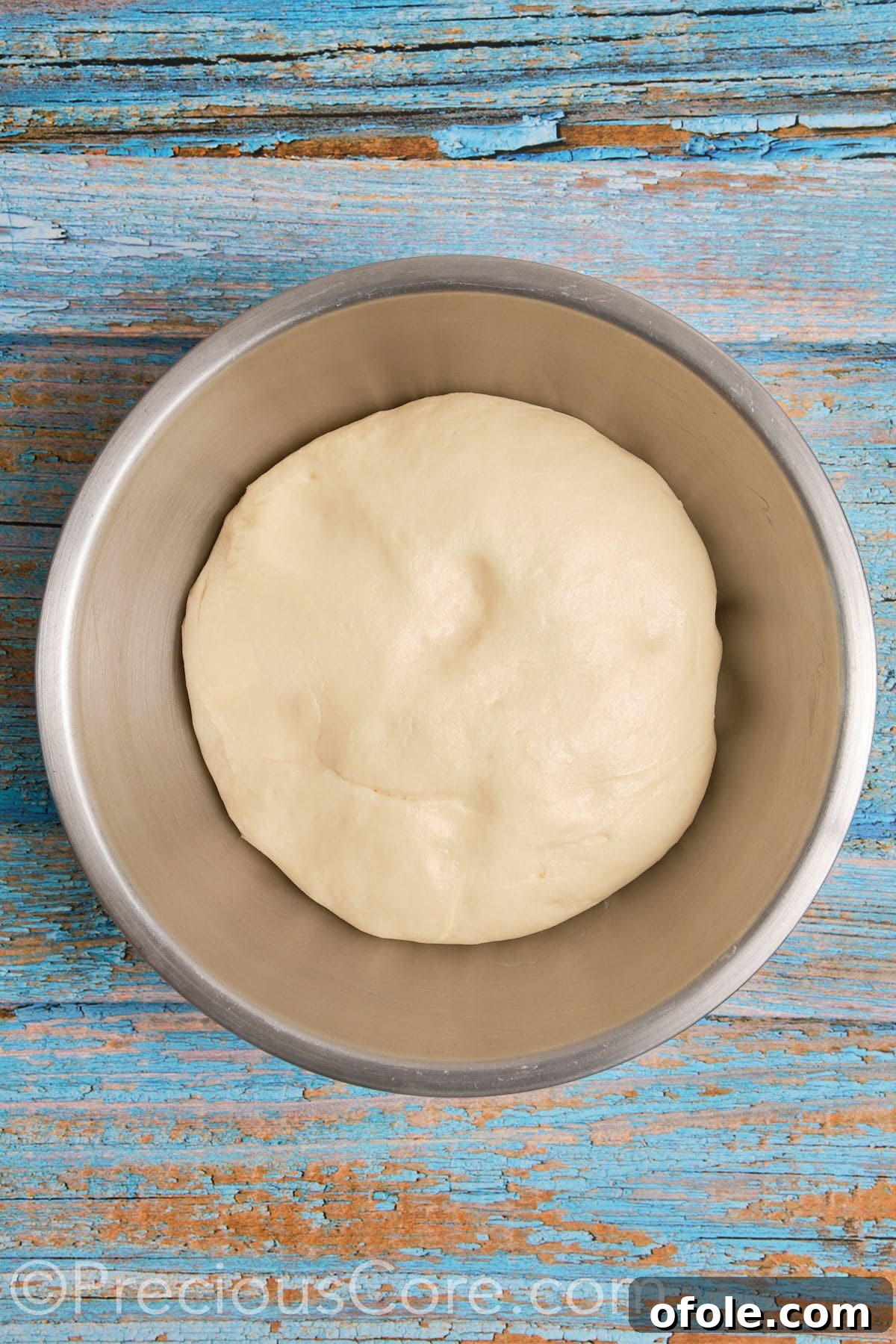 Homemade cinnamon roll dough after its first rise, having doubled beautifully in size in a mixing bowl.