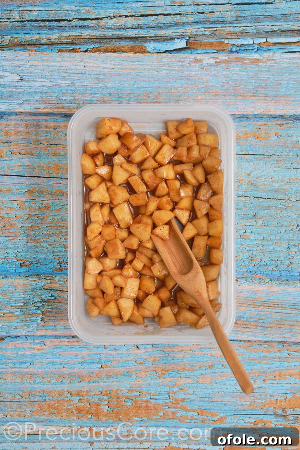 A bowl of freshly cooked apple pie filling, perfectly cooled and ready to be spread onto cinnamon roll dough.