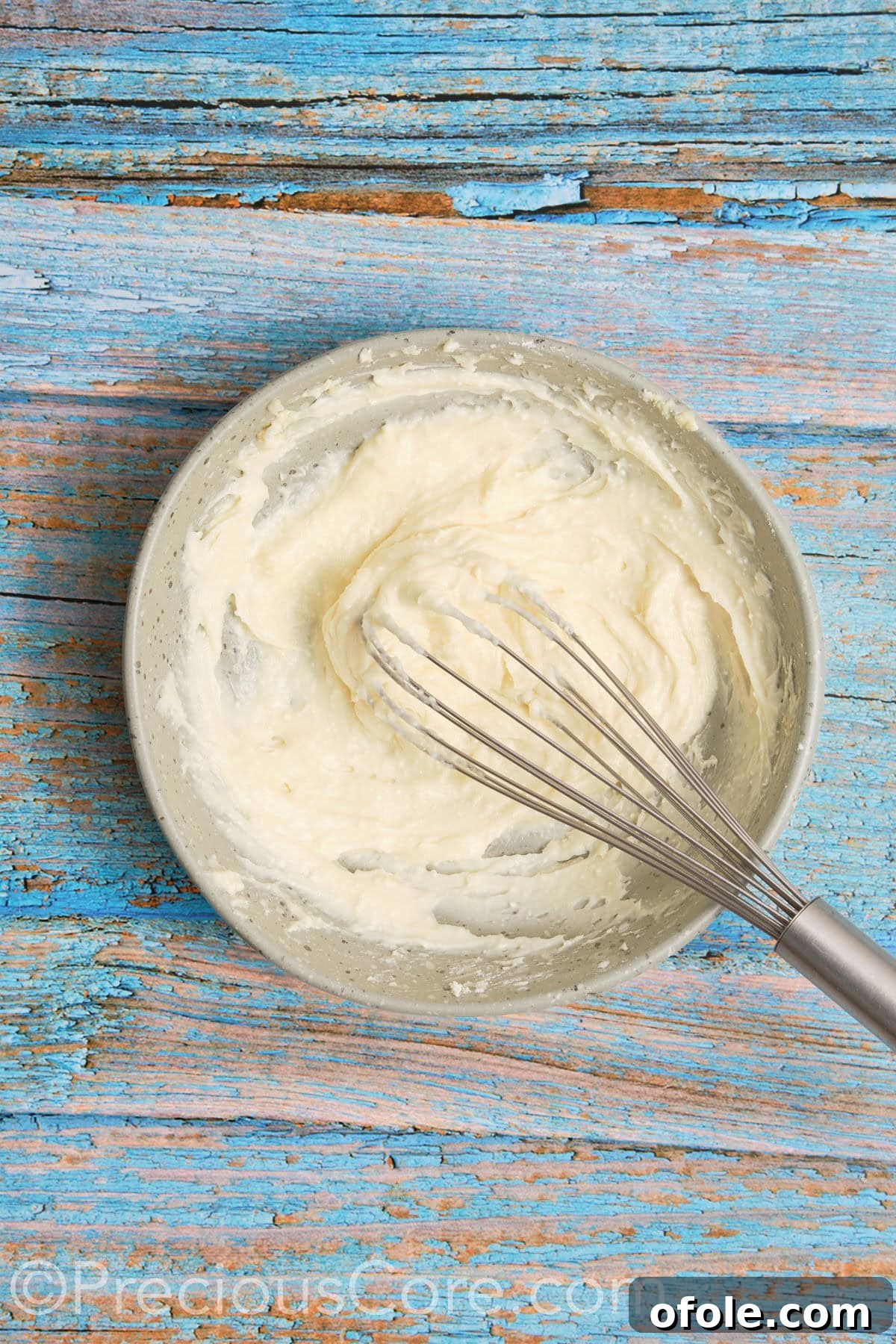 Creamy, smooth, and fluffy cream cheese frosting after being thoroughly mixed in a bowl.