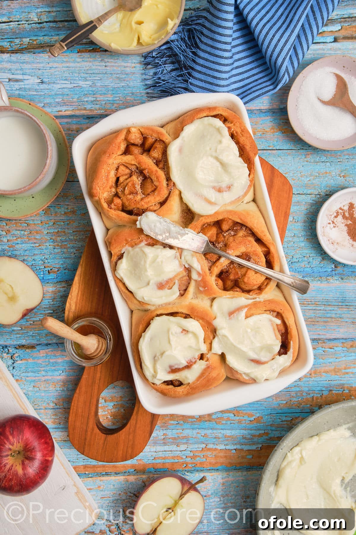 A wide shot of a baking dish filled with beautifully frosted Cinnamon Rolls with Apple Pie Filling, ready to be enjoyed.