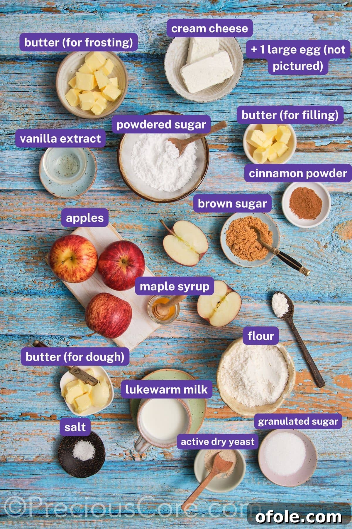 A flat lay photograph showcasing all the fresh and dry ingredients required for making Apple Pie Cinnamon Rolls, neatly arranged with labels.
