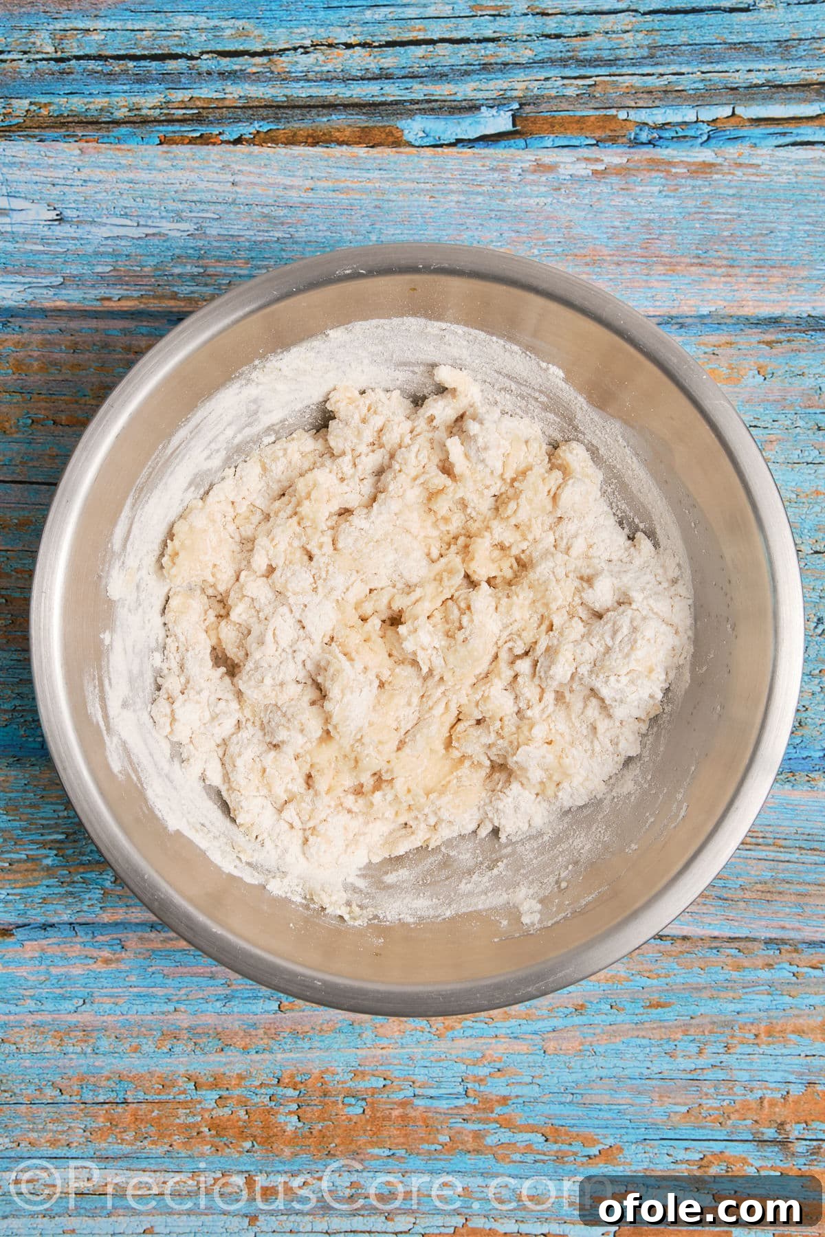 All-purpose flour being mixed into the wet ingredients for the cinnamon roll dough in a stand mixer.
