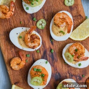 Cajun Shrimp Deviled Eggs 25 Deviled eggs with Cajun shrimp on a chopping board.