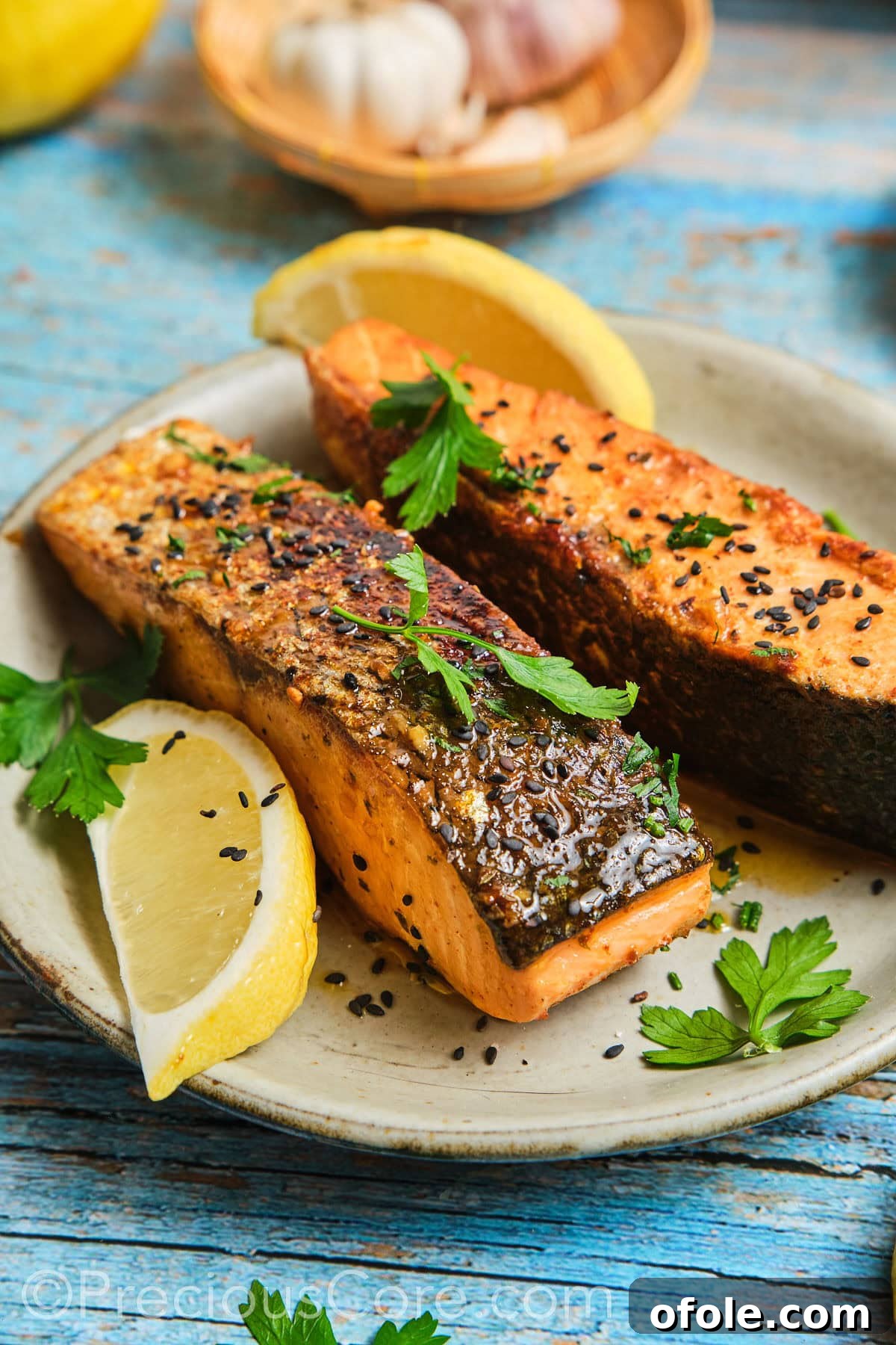 Cajun Honey Butter Salmon on a plate, garnished with fresh herbs and lemon.