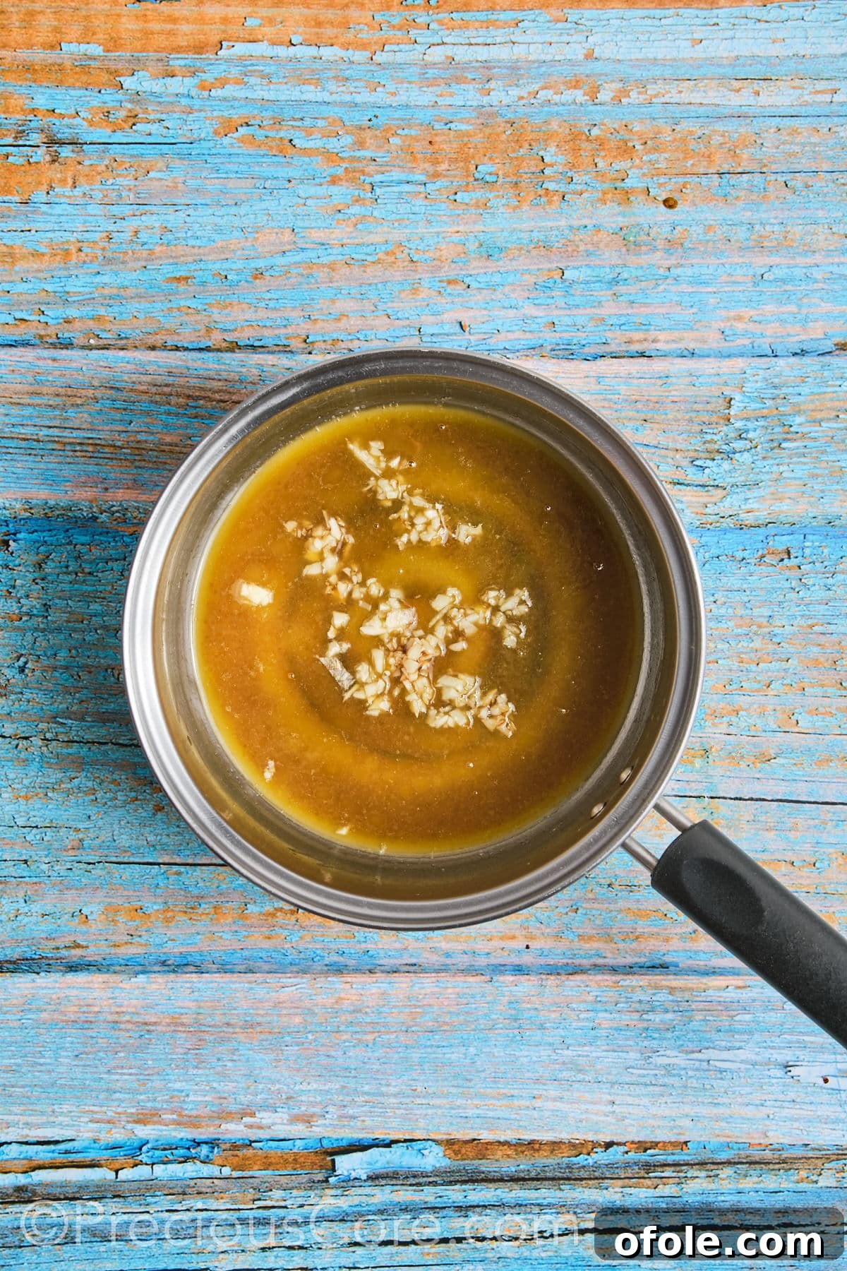 Making honey butter sauce in a small pot on the stove.