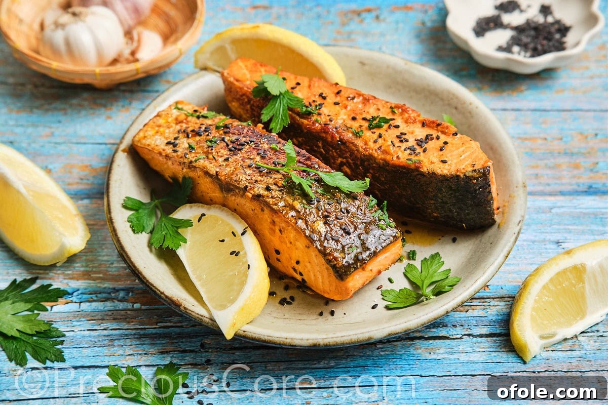 Landscape image of Cajun Honey Butter Salmon garnished with parsley and lemon.