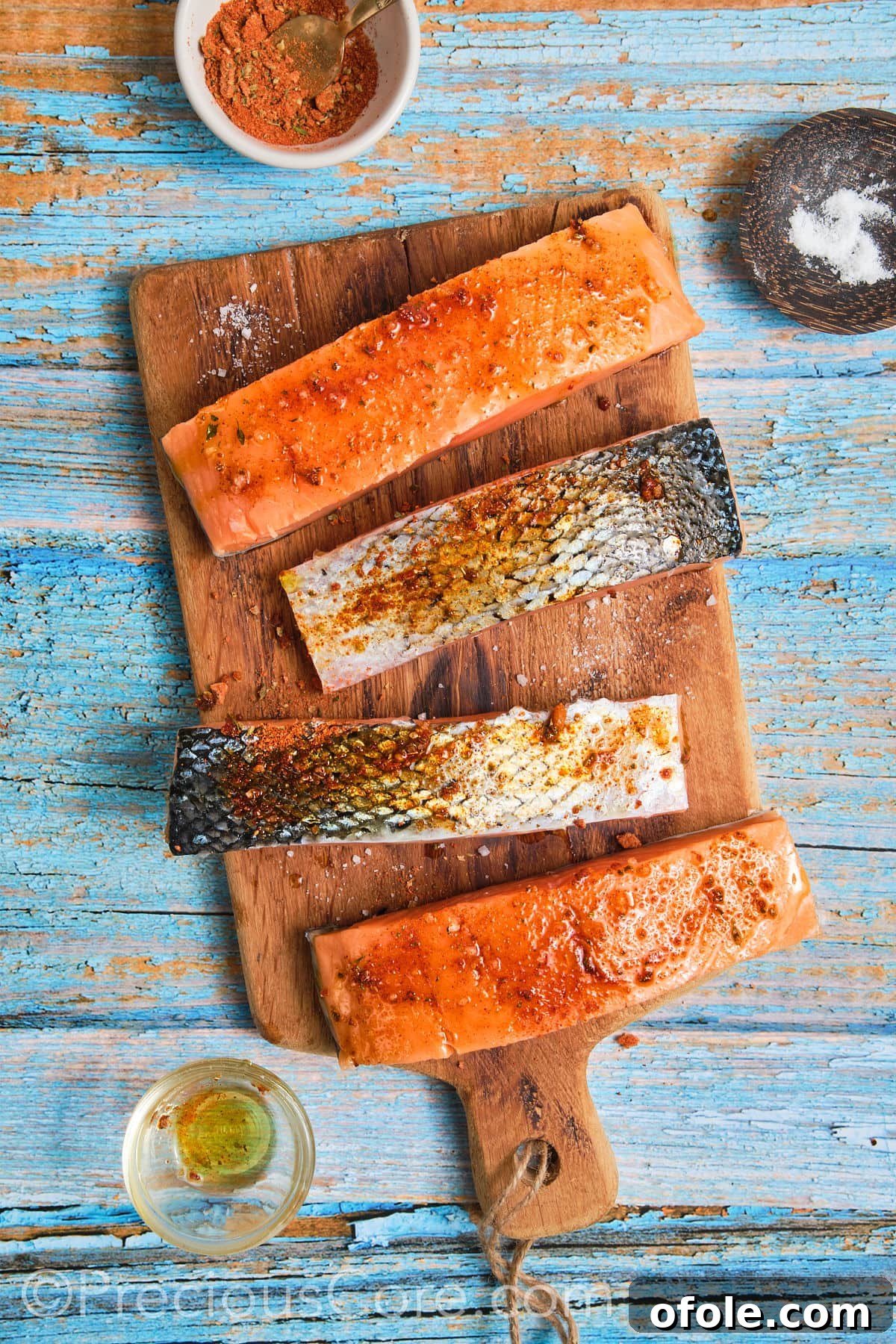 Salmon fillets coated generously with Cajun seasoning and olive oil.