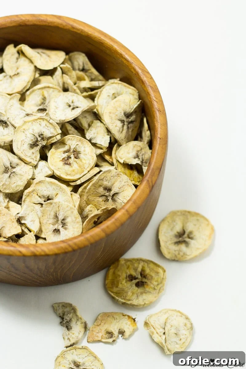 Wooden bowl of dried plantains, ready to be ground into flour.