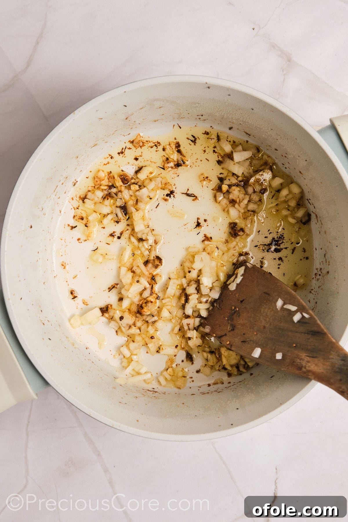One Pot Wonder Creamy Chicken Pasta 10 Sautéing onions and garlic in a pot.