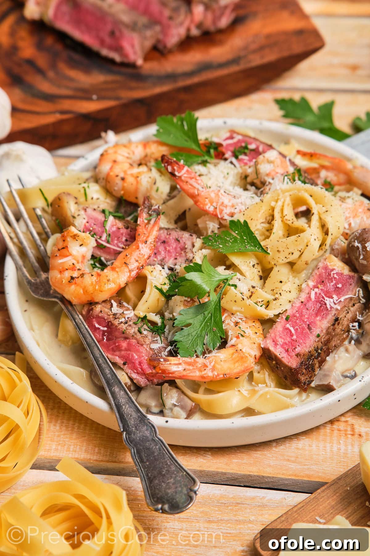 Land and Sea Pasta 13 Tagliatelle pasta dinner topped with black pepper and parmesan.