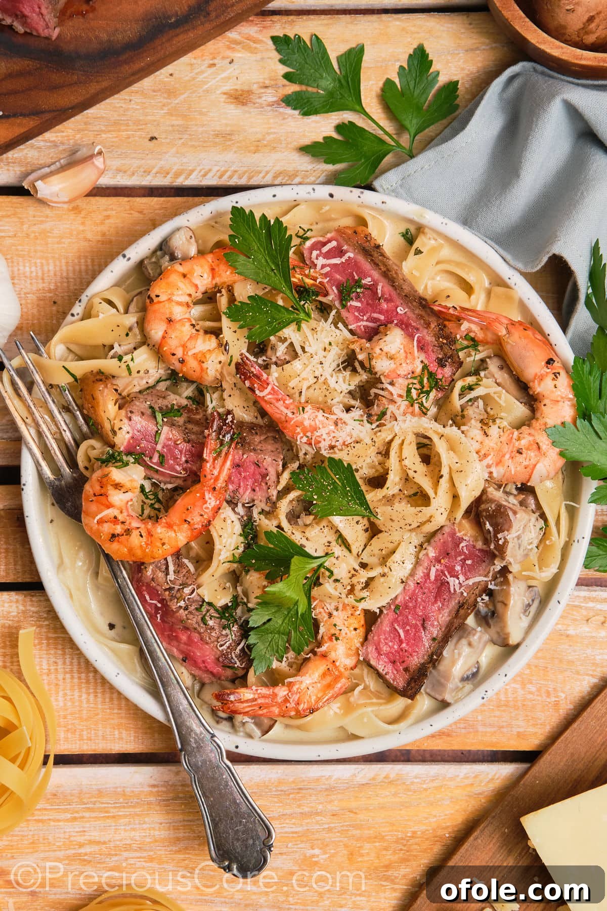 Land and Sea Pasta 6 Bowl of steak and shrimp pasta with a fork on the side.