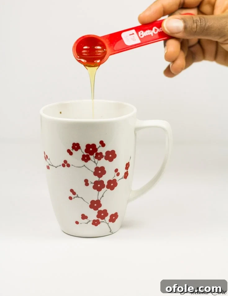 Tropical Coconut Hot Cocoa 6 Honey pouring into a floral mug.