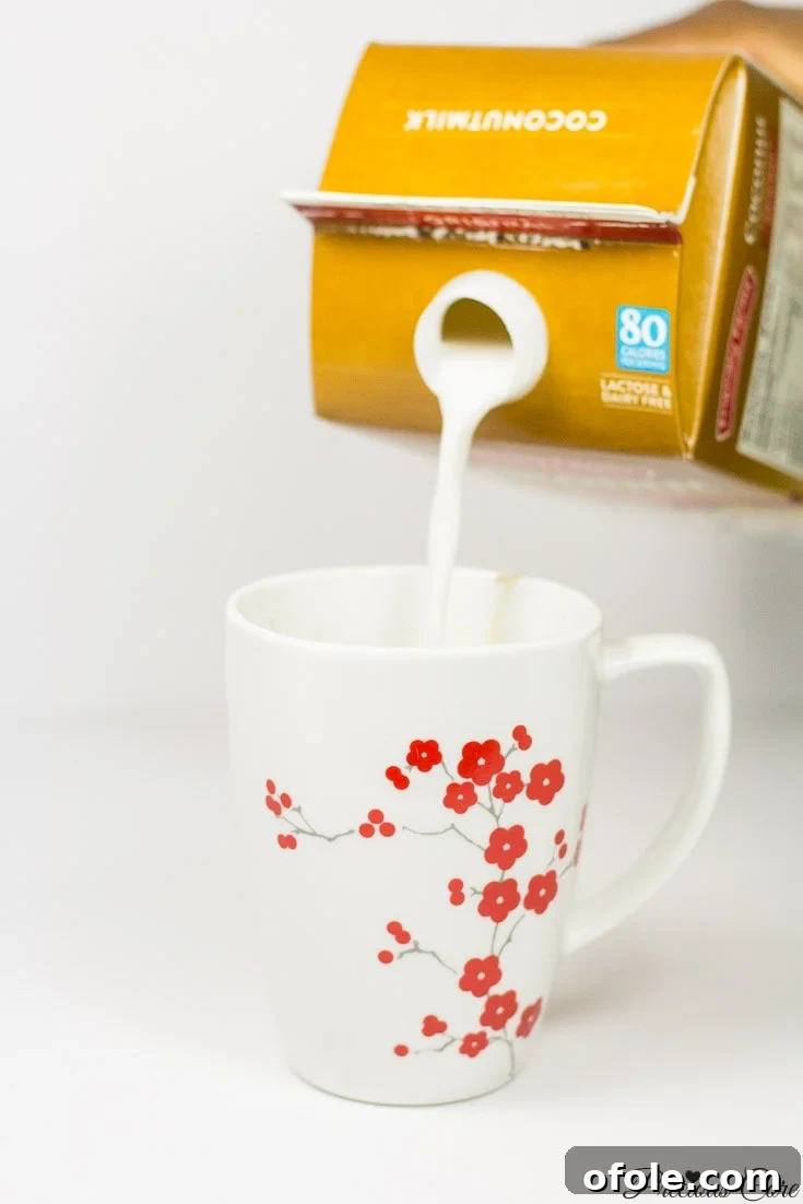 Tropical Coconut Hot Cocoa 7 Carton pouring coconut milk into a floral mug.