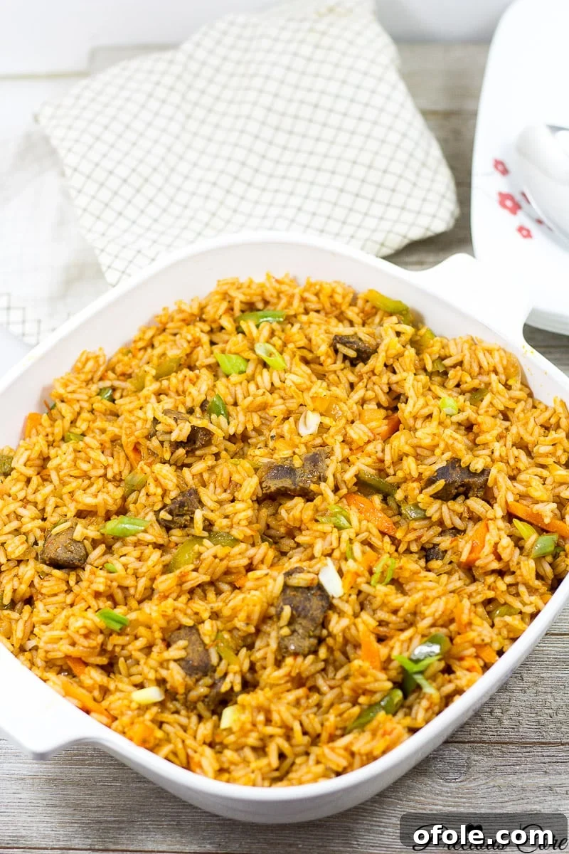 A perfectly prepared serving of Jollof Rice in a pristine white bowl, garnished simply.